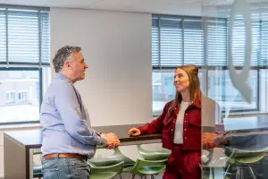 Vacature assistent aangiftemedewerker - foto van twee aangifte medewerkers in gesprek op het kantoor van Q belastingadviseurs.