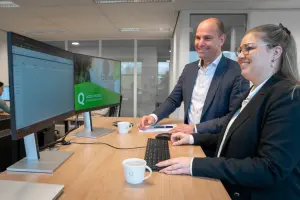 Vacature relatiebeheerder - foto van twee medewerkers aan een bureau bij Q.