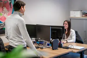 Vacature administratief medewerker - foto van twee administratief medewerkers in gesprek op het kantoor van Q accountants.