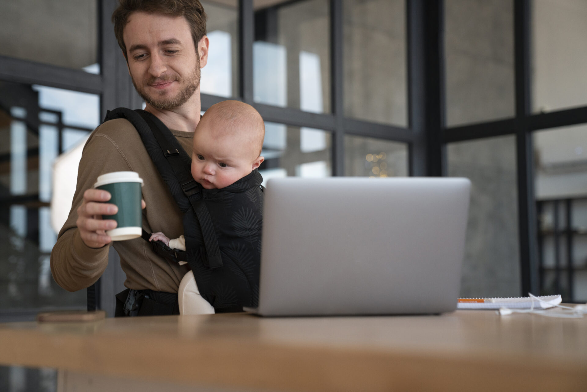 Geboorteverlof voor gewone werknemers, foto van vader aan het werk met baby